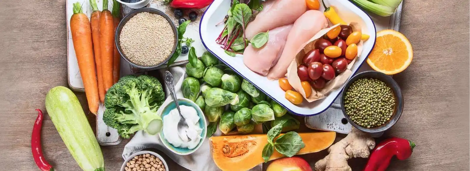 Ingrédients frais pour une cuisine sportive Protéalpes : légumes, fruits, quinoa et poulet, sans édulcorants ni additifs.