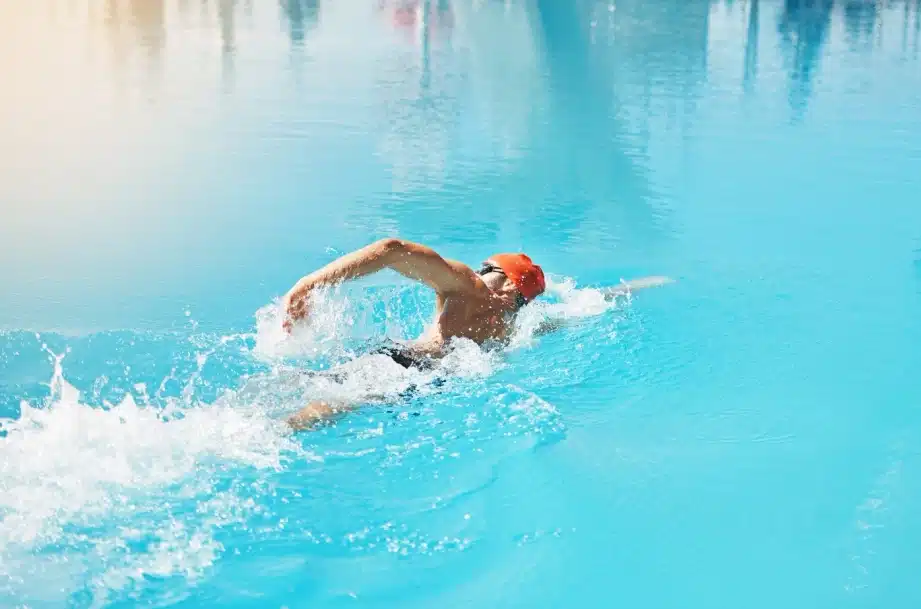 Nageur en action dans une piscine, symbolisant l'énergie et la pureté, valeurs des produits Protéalpes sans additifs.