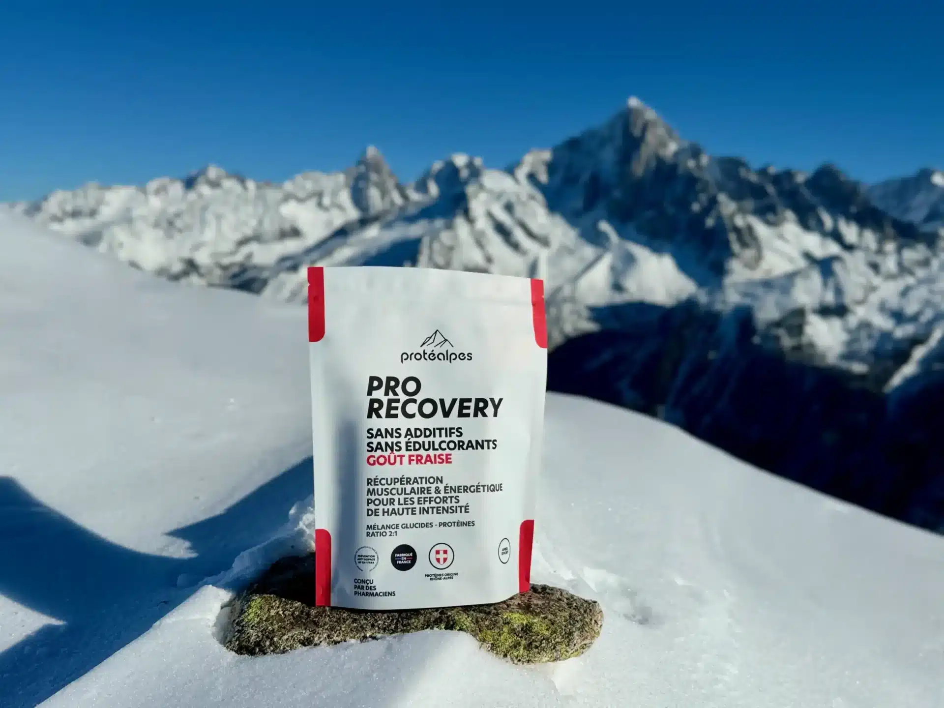 Produit ProRecovery Protéalpes sur fond alpin enneigé, nutrition sportive sans additifs ni édulcorants, goût fraise.