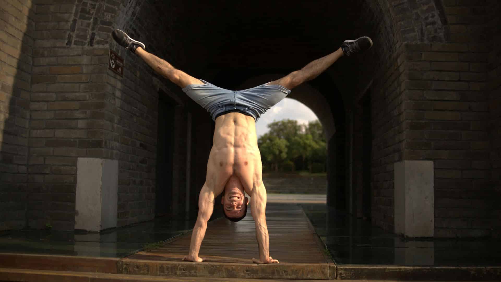 Un athlète fait le poirier, symbolisant l'équilibre et la force soutenus par la nutrition naturelle de Protéalpes.