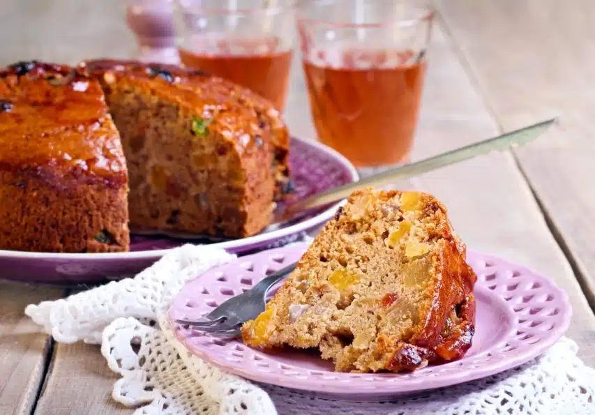Gâteau aux fruits naturels sur assiette rose et napperon blanc, reflet d'une nutrition authentique sans additifs ni édulcorants.