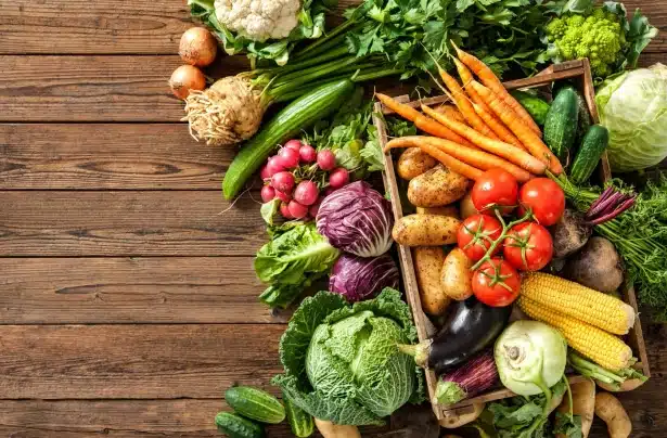Assortiment de légumes frais sur bois, idéal pour une nutrition sportive naturelle, sans additifs, à découvrir sur Protéalpes.