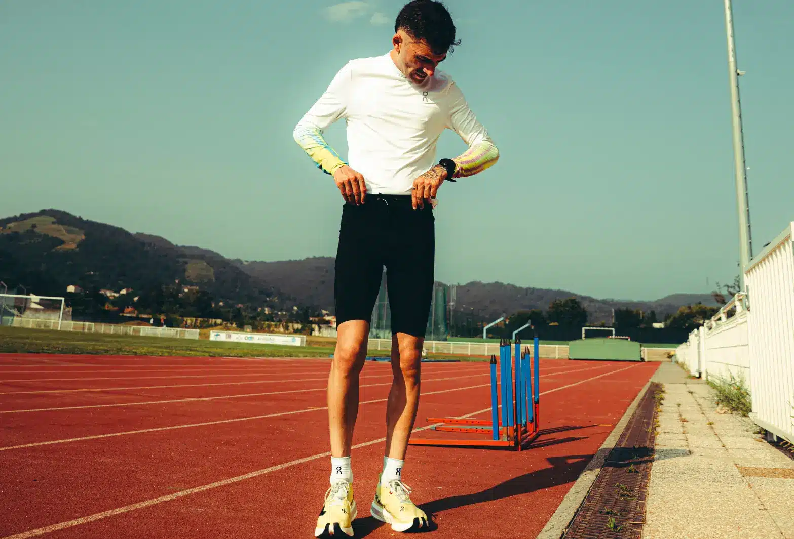 Athlète sur piste d'athlétisme, préparant un entraînement intense, symbolisant la nutrition sportive pure de Protéalpes.